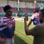 periodista entrevistando a un softbolista en el terreno