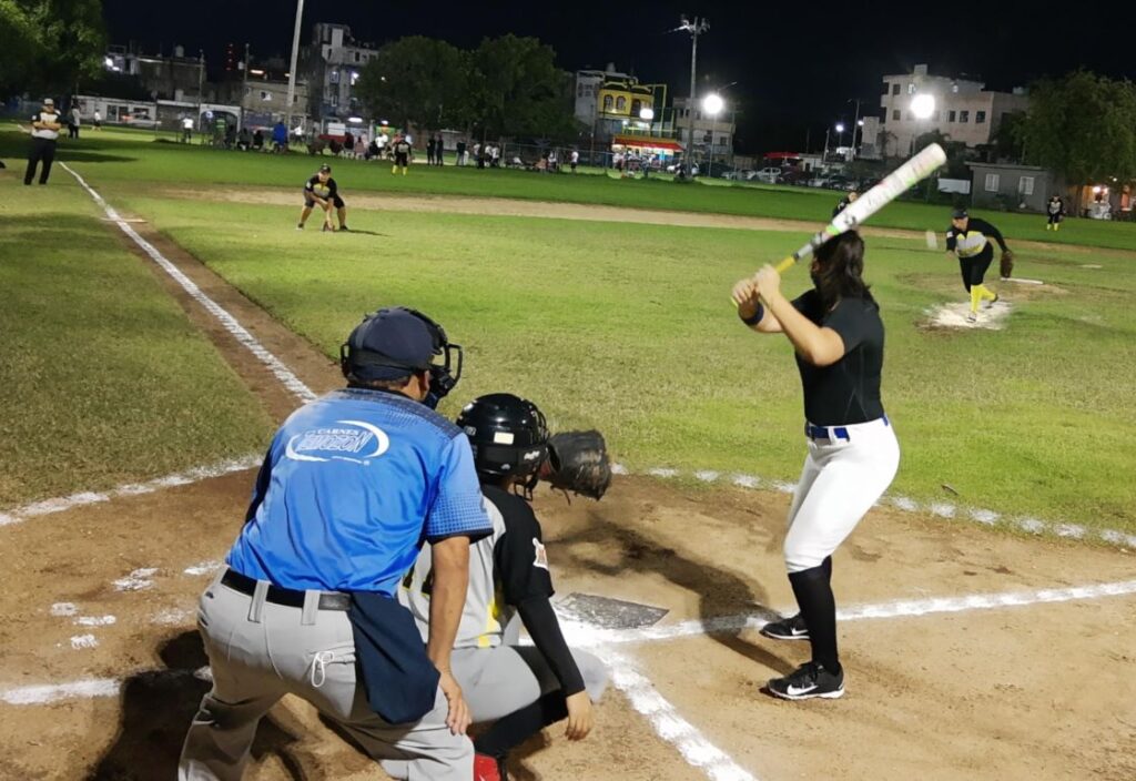 Chicas jugando softbol de noche