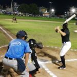 Chicas jugando softbol de noche